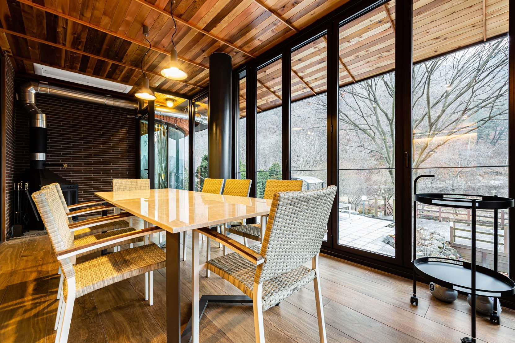 Dining area with wood beam ceiling and forest view
