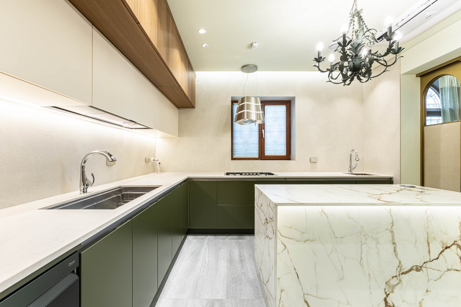 Kitchen with olive green cabinetry, marble island, and wrought iron chandelier
