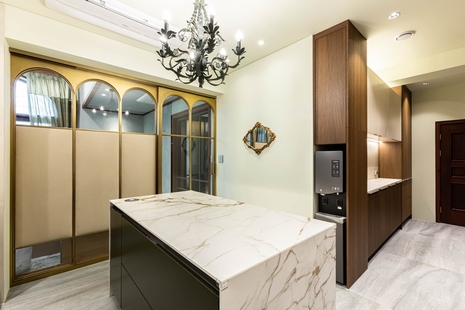 Pantry corner with arched brass-framed doors, marble island, and built-in water purifier