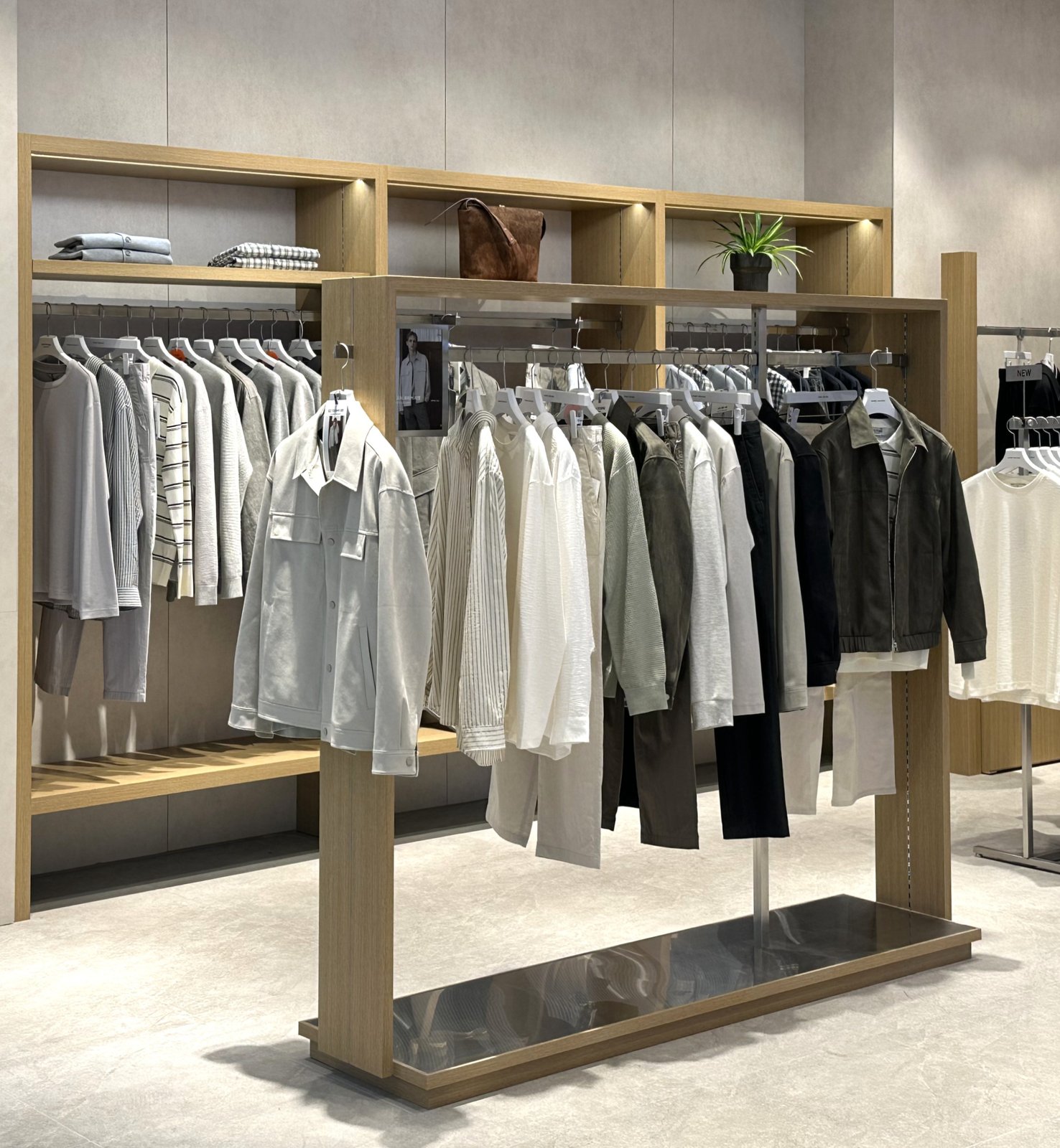 Open wood shelving rack with jackets and folded knitwear