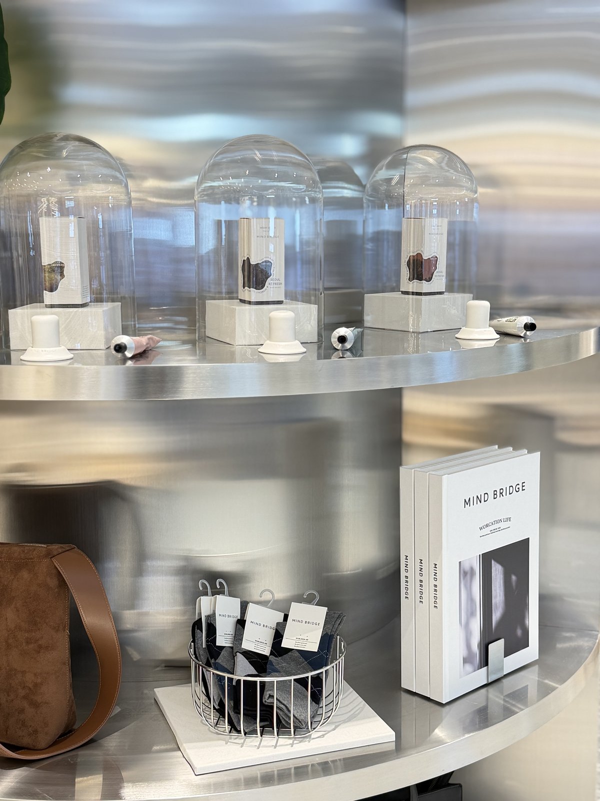 Stainless steel shelf with fragrance domes, socks basket, and Mind Bridge books