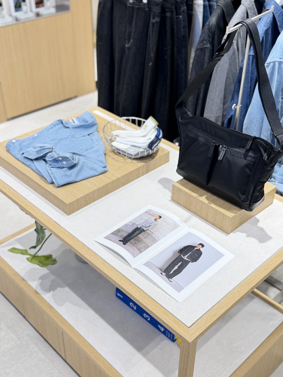Display table with denim shirt, tote bag, and lookbook